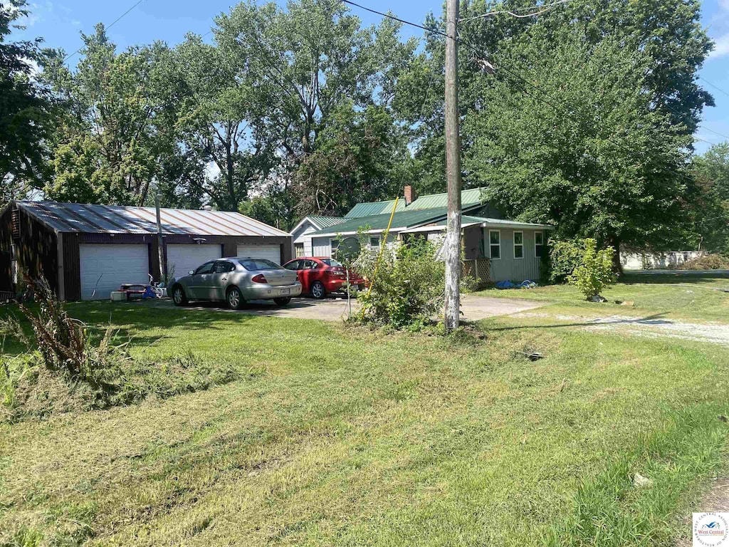 207 W 2nd St, Lowry City, MO 64763 - view of front of property featuring a garage, a front yard, and an outbuilding