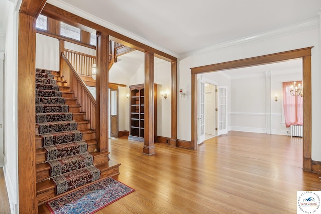 503 S 2nd St, Clinton, MO 64735 - stairway featuring radiator heating unit, wood finished floors, a chandelier, crown molding, and baseboards