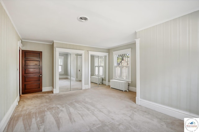 503 S 2nd St, Clinton, MO 64735 - unfurnished bedroom featuring radiator heating unit, multiple closets, ornamental molding, baseboards, and carpet floors