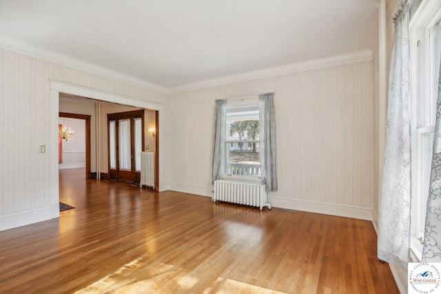 503 S 2nd St, Clinton, MO 64735 - unfurnished room with radiator, crown molding, wood finished floors, a chandelier, and baseboards