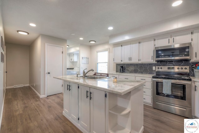 kitchen with a sink, visible vents, white cabinetry, appliances with stainless steel finishes, and wood finished floors