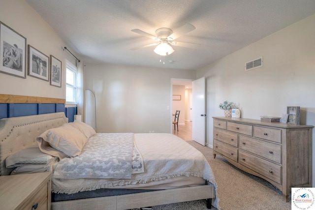 bedroom with a ceiling fan, visible vents, and light carpet