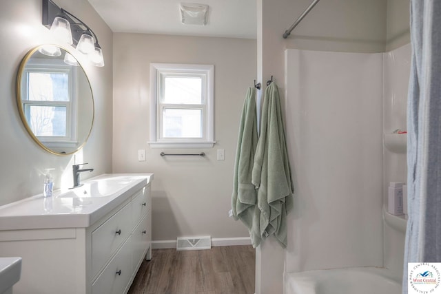 full bath with visible vents, wood finished floors, a wealth of natural light, and a shower