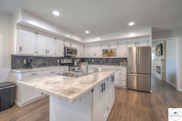 kitchen featuring light wood-type flooring, white cabinetry, stainless steel appliances, and open shelves