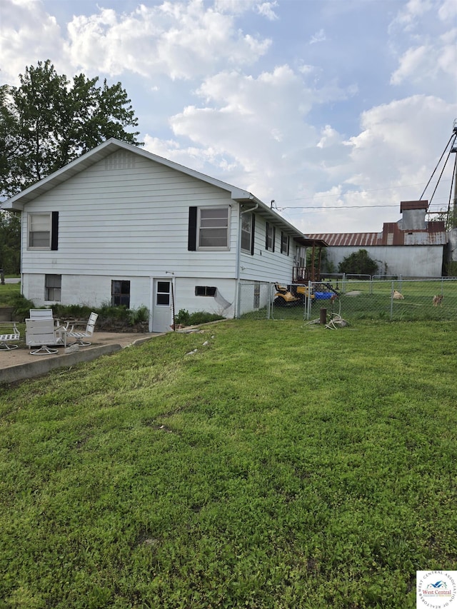 back of property featuring a lawn, a patio area, and fence