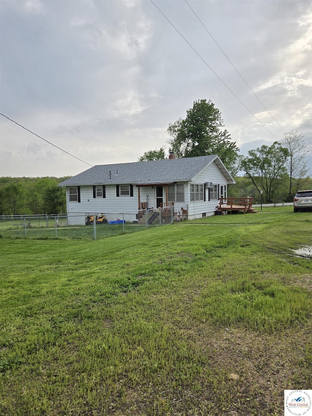 single story home featuring fence, a chimney, a front yard, and a wooden deck