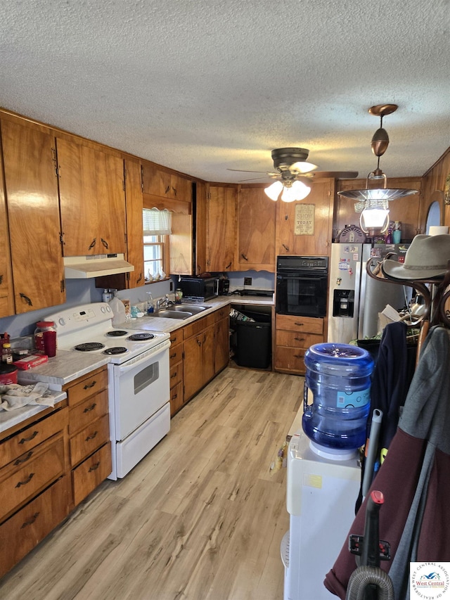 kitchen featuring black oven, brown cabinetry, electric stove, dishwashing machine, and under cabinet range hood