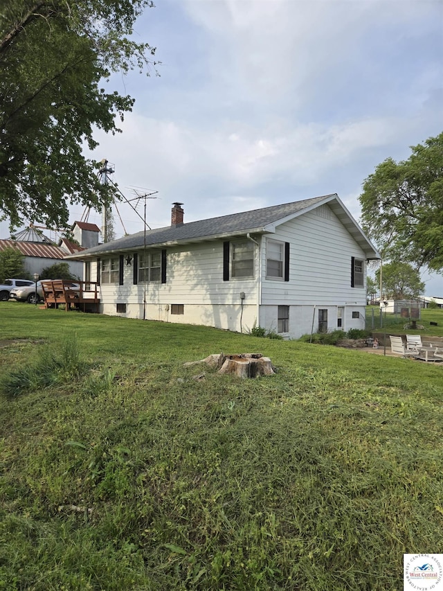 view of side of home with a lawn and a chimney