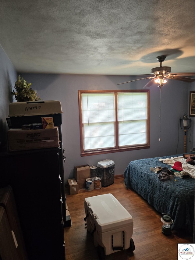 bedroom featuring a textured ceiling, ceiling fan, and wood finished floors
