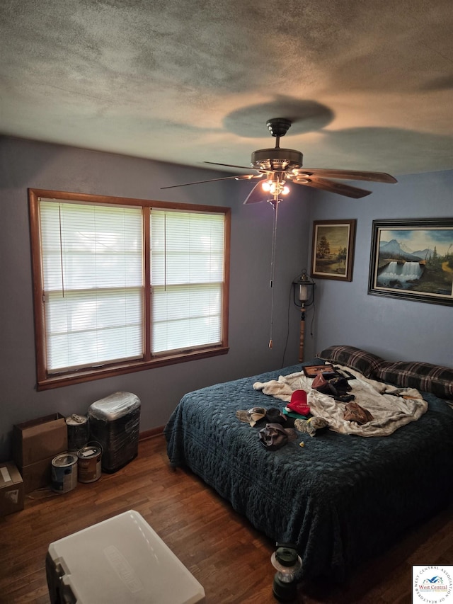 bedroom featuring a textured ceiling, ceiling fan, and wood finished floors