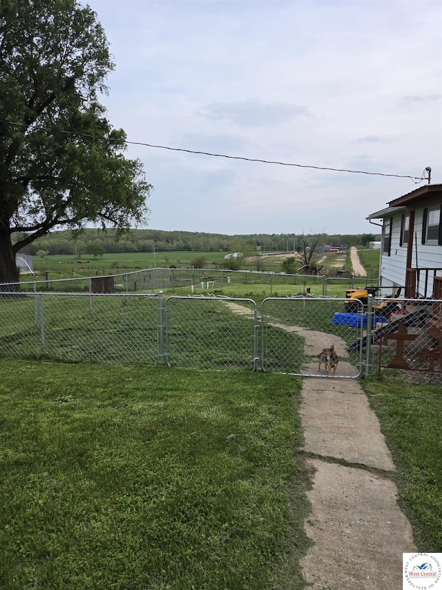 view of yard featuring a gate, fence, and a rural view