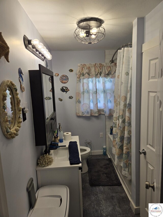 bathroom with vanity, toilet, shower / bathtub combination with curtain, baseboards, and wood finished floors