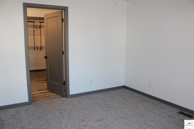 empty room with visible vents, carpet floors, and baseboards