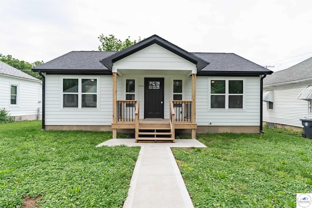 704 E 16th St, Sedalia, MO 65301 - bungalow featuring a porch, a front lawn, and roof with shingles