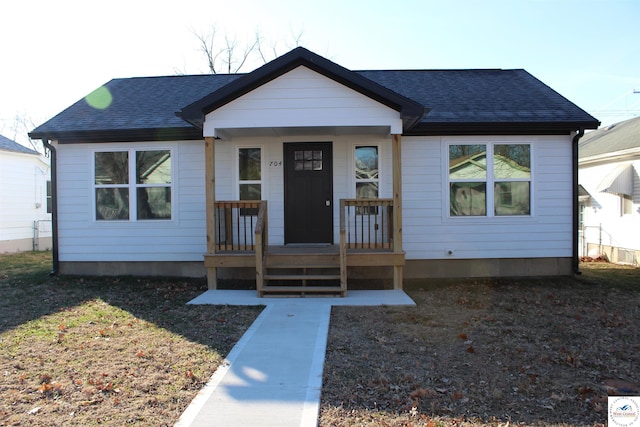 bungalow-style house with roof with shingles and a porch