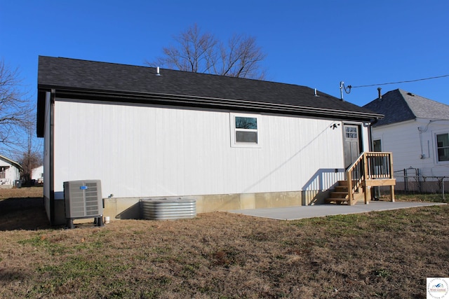 rear view of house featuring cooling unit, a yard, and a patio