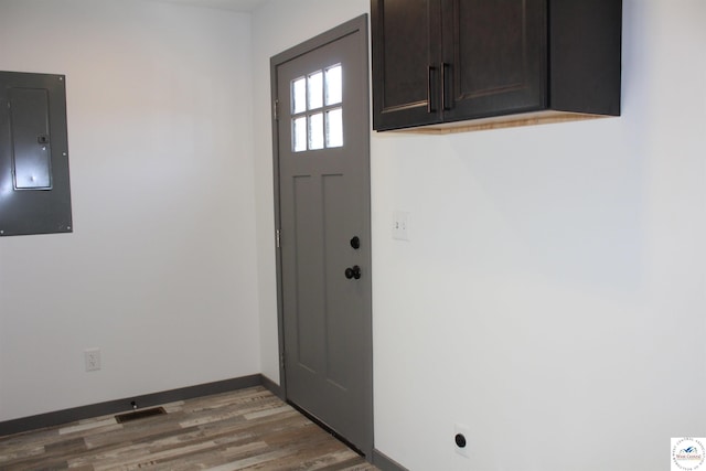 doorway to outside featuring visible vents, wood finished floors, electric panel, and baseboards