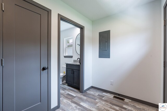 704 E 16th St, Sedalia, MO 65301 - hallway featuring electric panel, light wood finished floors, baseboards, and a sink