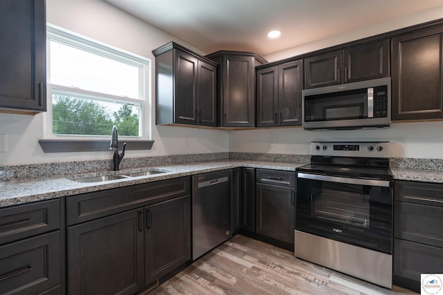 704 E 16th St, Sedalia, MO 65301 - kitchen featuring appliances with stainless steel finishes, a sink, light wood-type flooring, light stone countertops, and recessed lighting