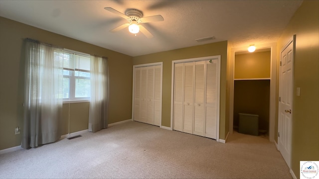 21609 Valley Rd, Warsaw, MO 65355 - unfurnished bedroom featuring baseboards, visible vents, light colored carpet, and multiple closets