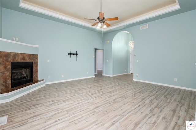 3375 Cedar St, Sedalia, MO 65301 - unfurnished living room featuring a raised ceiling, arched walkways, a ceiling fan, wood finished floors, and ornamental molding
