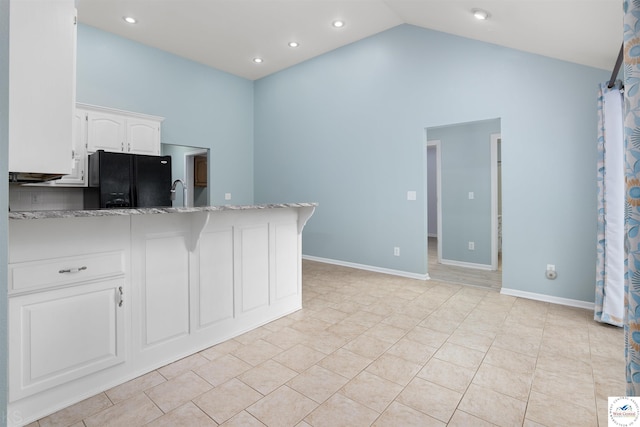 3375 Cedar St, Sedalia, MO 65301 - kitchen with freestanding refrigerator, high vaulted ceiling, light stone countertops, a peninsula, and white cabinets