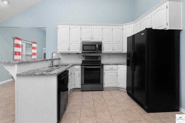 3375 Cedar St, Sedalia, MO 65301 - kitchen with black appliances, a peninsula, light stone counters, white cabinetry, and high vaulted ceiling