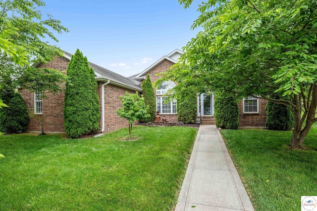 3375 Cedar St, Sedalia, MO 65301 - obstructed view of property featuring brick siding, a front lawn, and roof with shingles