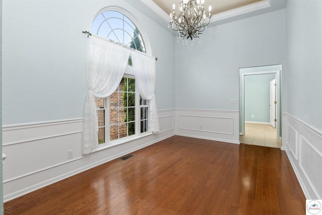 3375 Cedar St, Sedalia, MO 65301 - unfurnished dining area with a chandelier, wood-type flooring, a wainscoted wall, a decorative wall, and ornamental molding