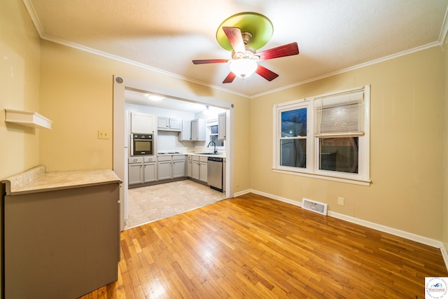 1315 Maple Ln, Sedalia, MO 65301 - interior space with light wood-style flooring, stainless steel appliances, ceiling fan, a sink, and visible vents