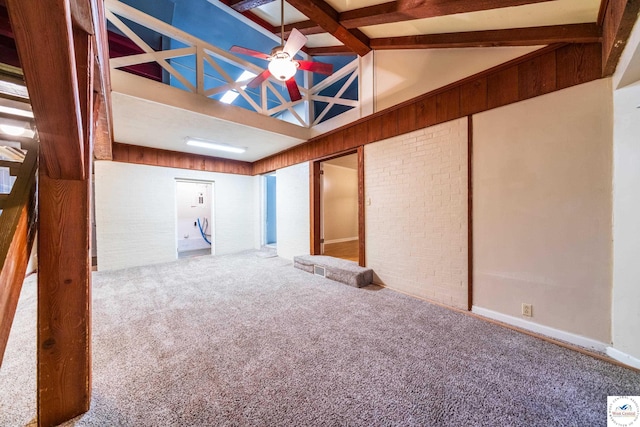 1315 Maple Ln, Sedalia, MO 65301 - spare room featuring lofted ceiling with beams, a ceiling fan, carpet, and brick wall