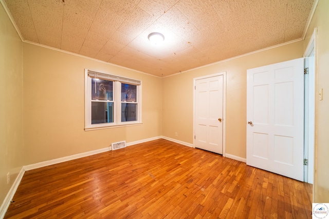 1315 Maple Ln, Sedalia, MO 65301 - spare room featuring crown molding, visible vents, baseboards, and wood-type flooring
