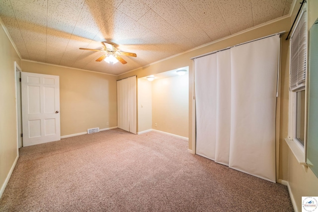 1315 Maple Ln, Sedalia, MO 65301 - unfurnished bedroom featuring crown molding, ceiling fan, visible vents, carpet, and multiple closets