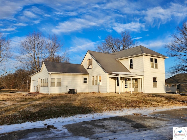 view of front of house with a porch, metal roof, and central AC unit
