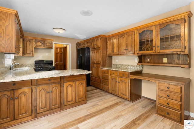5900 Apple Rd, Sedalia, MO 65301 - kitchen featuring built in desk, a sink, light wood-style floors, black appliances, and a peninsula