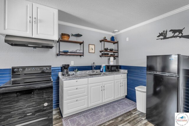 21439 Lost Rd, Warsaw, MO 65355 - kitchen with a textured ceiling, a sink, under cabinet range hood, black appliances, and wood finished floors