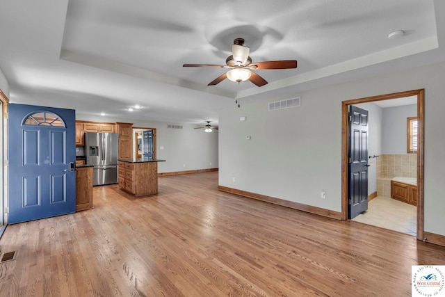 21439 Lost Rd, Warsaw, MO 65355 - unfurnished living room with visible vents, a raised ceiling, and a ceiling fan