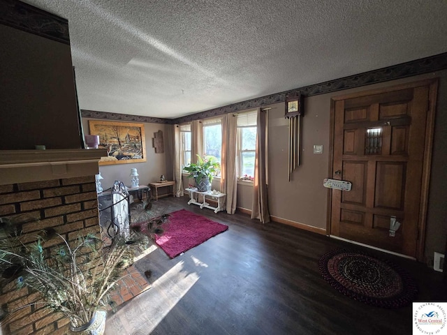 512 N Price Ln, Clinton, MO 64735 - foyer with baseboards, wood finished floors, a textured ceiling, and a fireplace