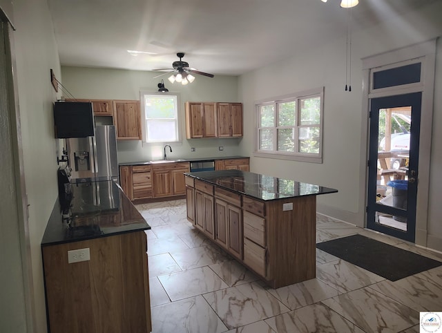1105 Lay Ave, Warsaw, MO 65355 - kitchen featuring stainless steel appliances, ceiling fan, dark countertops, light marble finish flooring, and a kitchen island