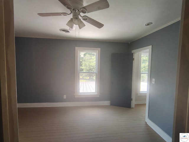 1105 Lay Ave, Warsaw, MO 65355 - spare room featuring hardwood / wood-style flooring, healthy amount of natural light, a ceiling fan, and crown molding