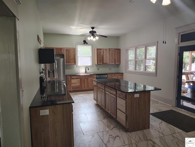 1105 Lay Ave, Warsaw, MO 65355 - kitchen with stainless steel appliances, ceiling fan, a center island, light marble finish floors, and brown cabinetry