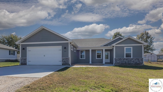 view of front of property with a front lawn, driveway, stone siding, and an attached garage