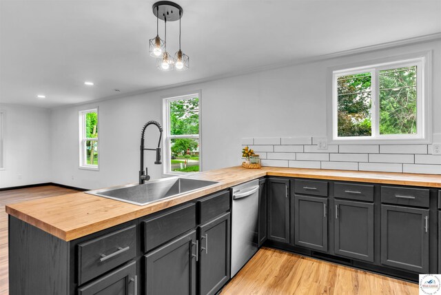 1401 S Park Ave, Sedalia, MO 65301 - kitchen with butcher block countertops, a sink, stainless steel dishwasher, light wood-type flooring, and a peninsula