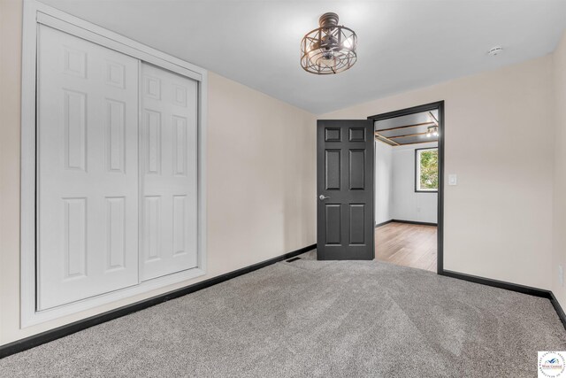 1401 S Park Ave, Sedalia, MO 65301 - unfurnished bedroom featuring carpet, baseboards, a closet, and vaulted ceiling