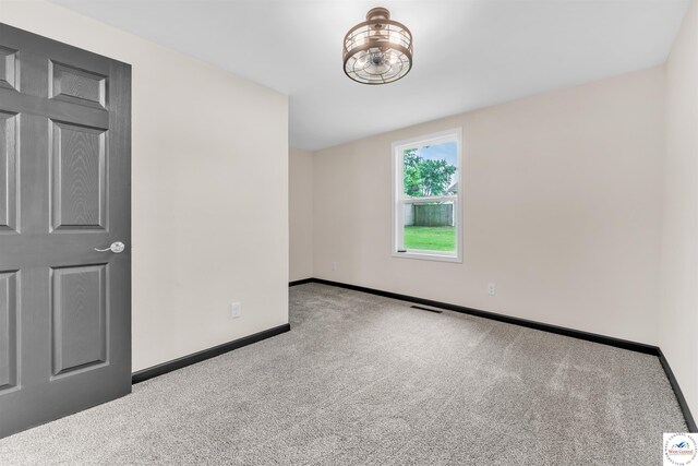 1401 S Park Ave, Sedalia, MO 65301 - carpeted empty room with baseboards and a chandelier