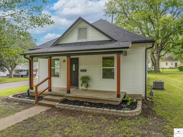 1401 S Park Ave, Sedalia, MO 65301 - view of front of property featuring a porch, a shingled roof, central AC unit, and a front lawn