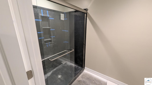 full bath with a stall shower and baseboards