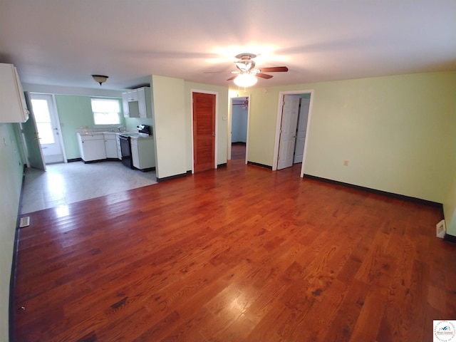 206 N Ohio St, Chilhowee, MO 64733 - unfurnished living room with baseboards, wood finished floors, ceiling fan, and a sink