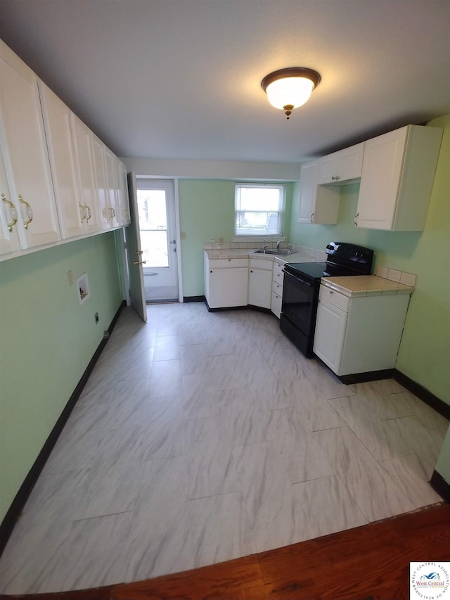 206 N Ohio St, Chilhowee, MO 64733 - kitchen with white cabinetry, black electric range, baseboards, and plenty of natural light