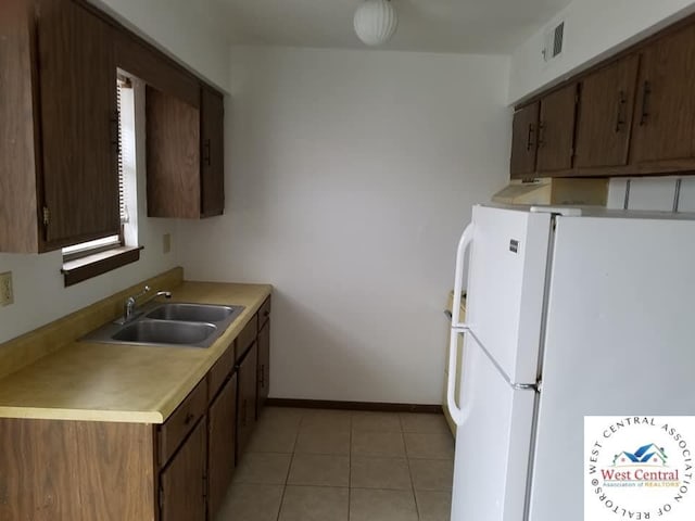 206 N Ohio St, Chilhowee, MO 64733 - kitchen with freestanding refrigerator, light countertops, a sink, baseboards, and visible vents